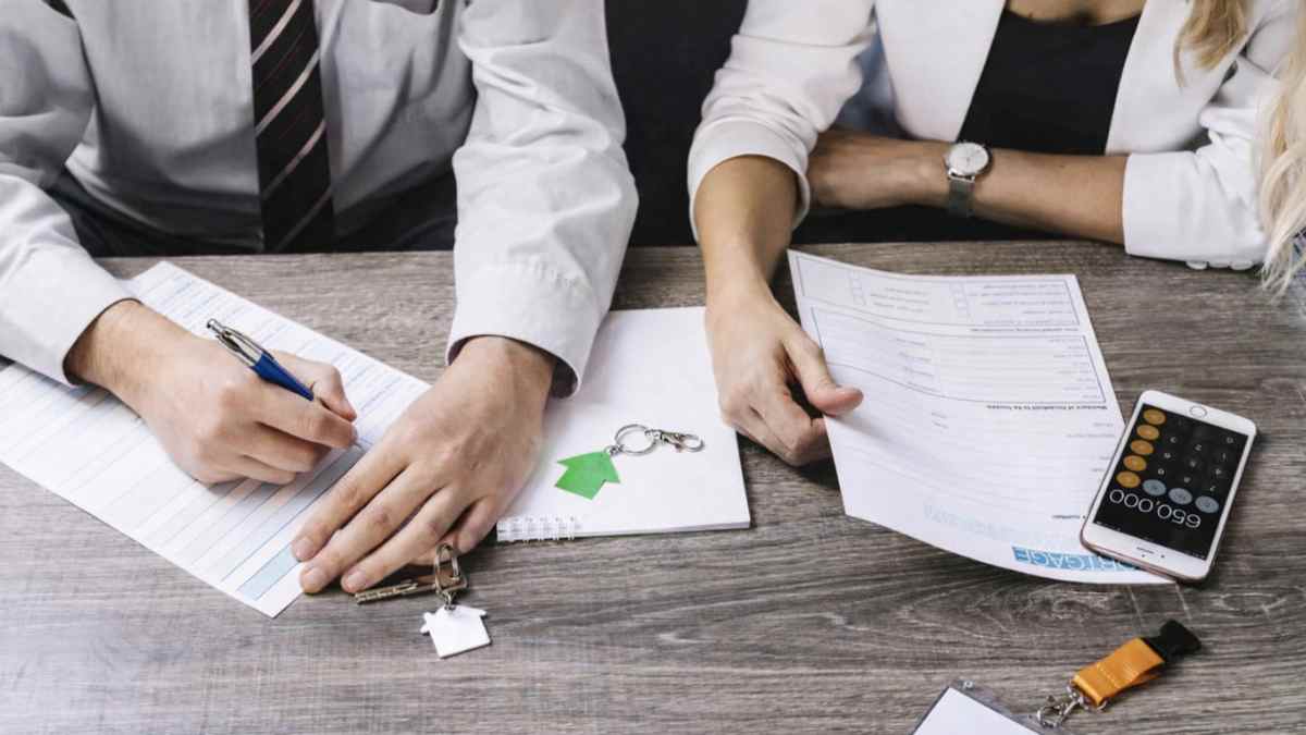 Inquilinos firmando un contrato de alquiler con una inmobiliaria en Madrid tras la denuncia de la OCU por cobro de comisiones