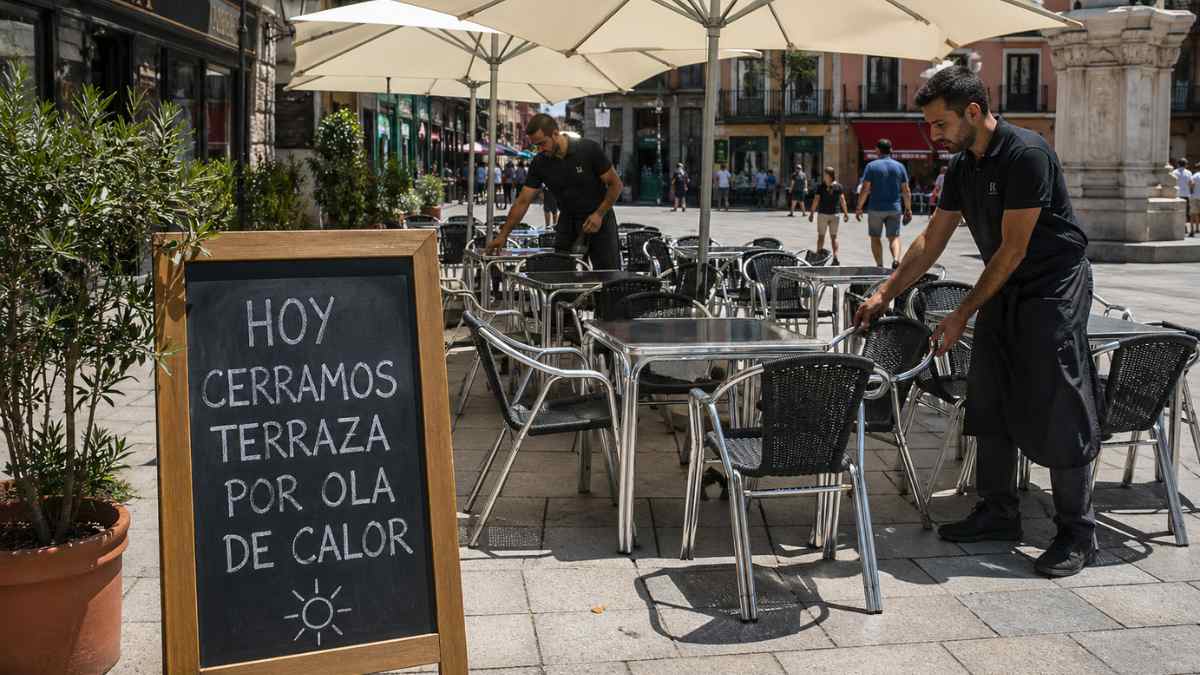Camareros recogen terraza de bar cerrada por ola de calor en España por nueva normativa laboral