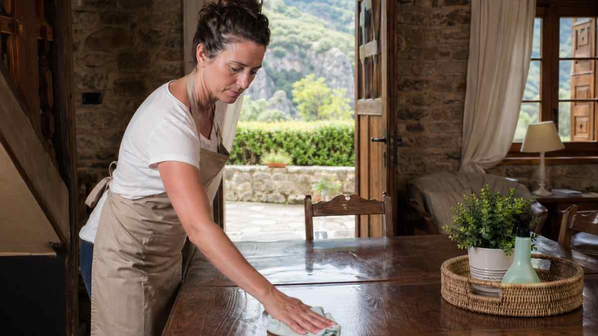 Trabajadora limpiando mesa en casa rural durante baja médica por vesícula en caso de despido improcedente