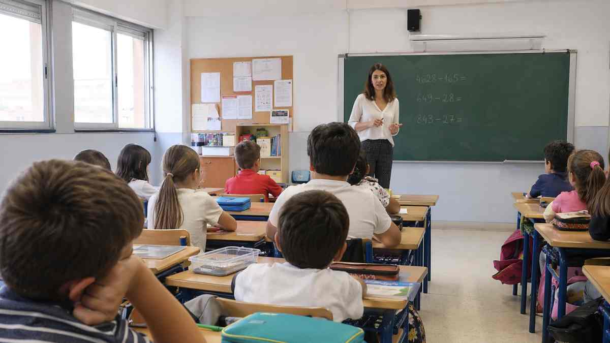 clase de primaria con menos alumnos y profesora explicando nueva ley educativa en España