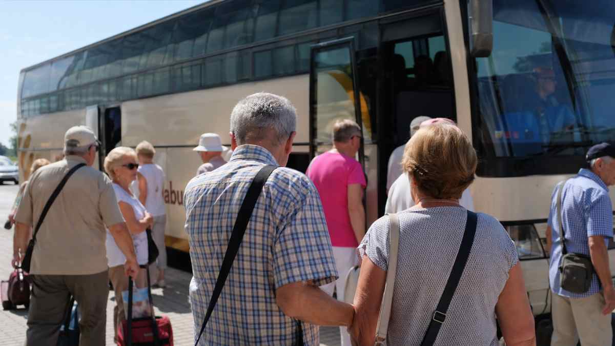 Mayores de 60 años subiendo a un autobús del Imserso para viajar con el programa de turismo social