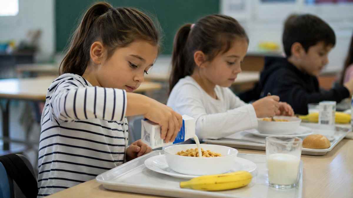 Niños desayunando en un comedor escolar de Madrid beneficiados por las ayudas de desayuno escolar para familias con IMV y RMI