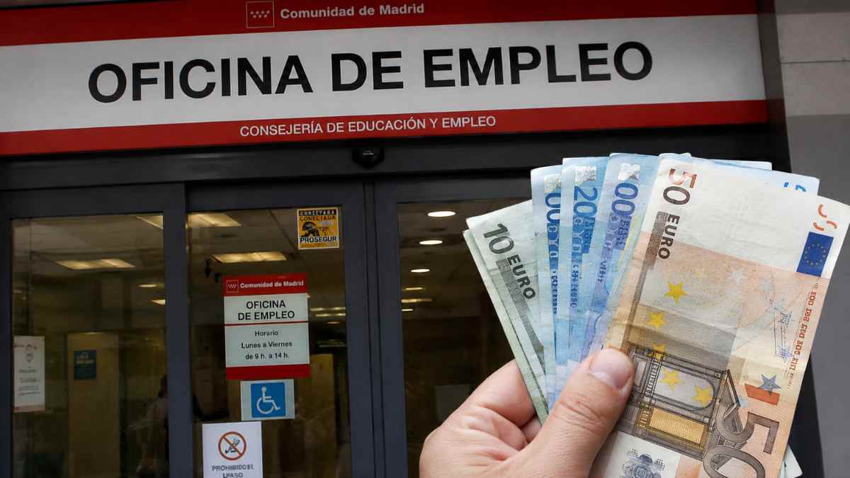 Persona mostrando billetes de euro frente a una oficina de empleo tras agotar el paro y solicitar el Ingreso Mínimo Vital