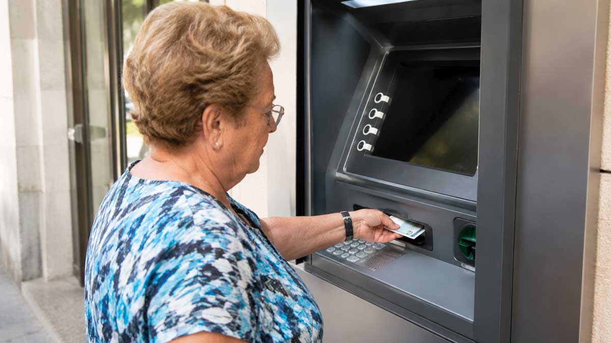 Mujer mayor usando un cajero automático para consultar pensiones en julio de 2026