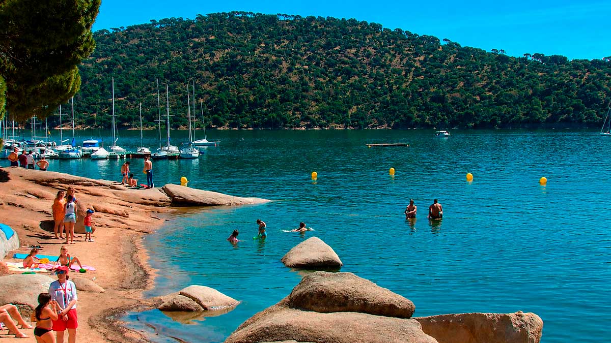 Playa de Madrid en el embalse de San Juan con Bandera Azul y bañistas disfrutando del agua