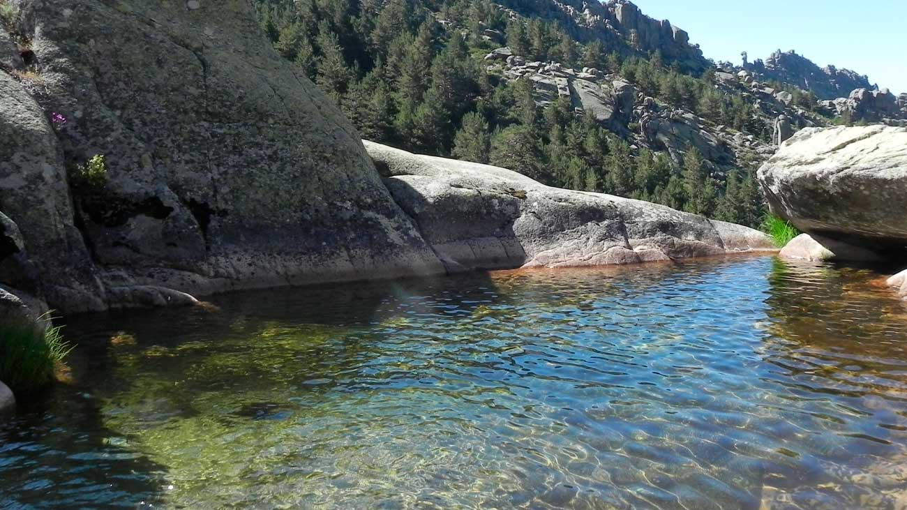Piscina natural en La Pedriza rodeada de rocas y vegetación, bañarse prohibido este verano