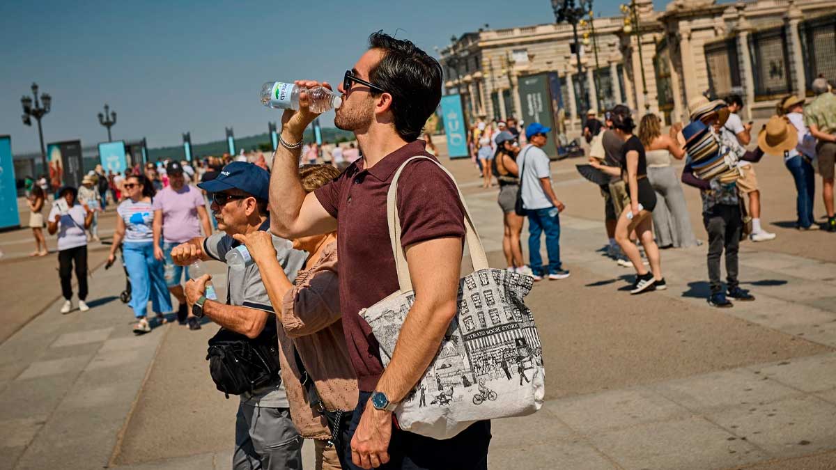 Personas en Madrid bebiendo agua durante una ola de calor extremo y radiación ultravioleta muy alta