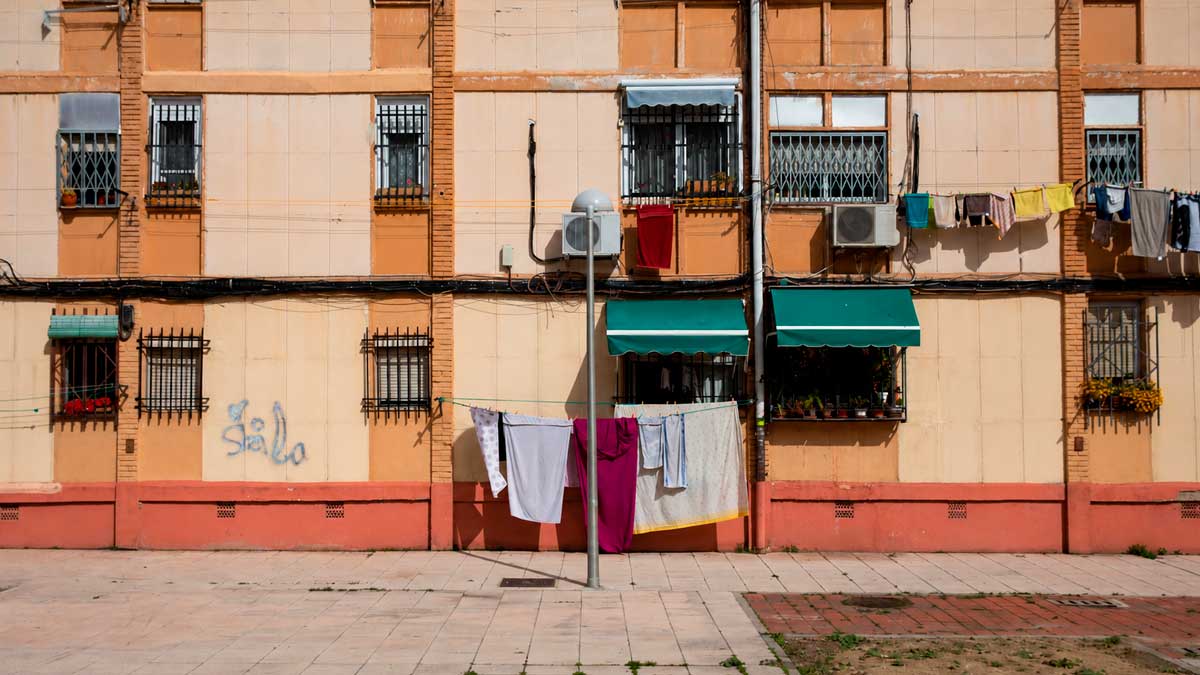 Fachada de edificio en barrio barato de Madrid con ropa tendida y aire acondicionado
