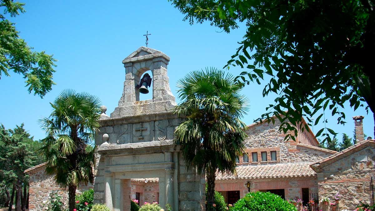 Ermita visigoda en la sierra de Madrid rodeada de vegetación y cielo azul