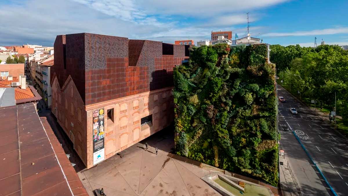 Fachada verde del CaixaForum Madrid, sede de exposiciones inmersivas en la ciudad