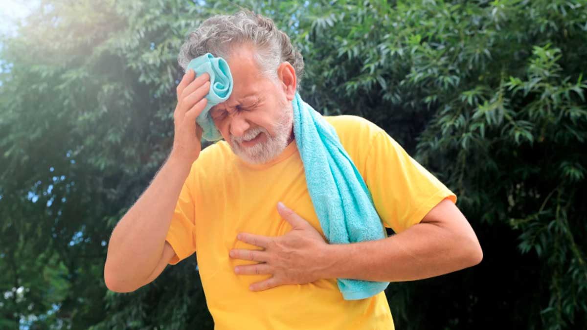 Hombre mayor afectado por calor en Madrid, tocándose la frente y el pecho