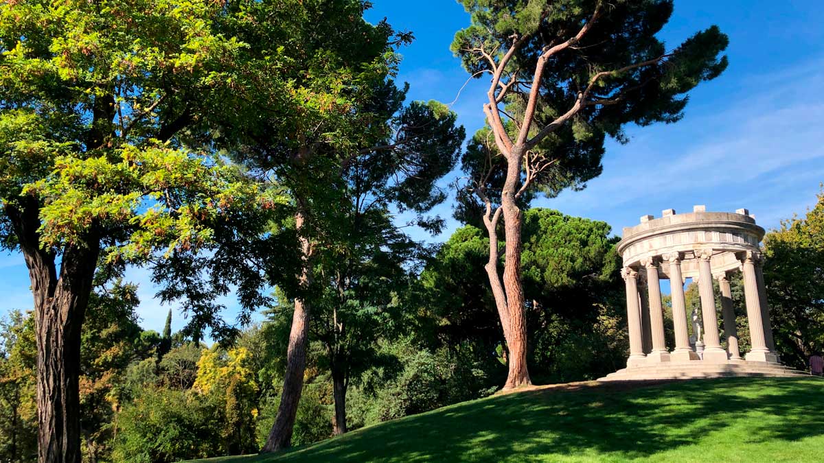 Templo circular rodeado de árboles en un parque con sombra en Madrid