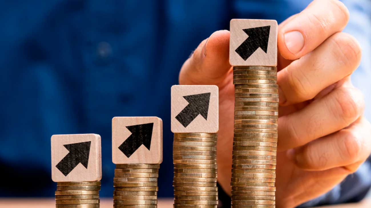 Crecimiento de salarios en Madrid representado con monedas apiladas y flechas ascendentes