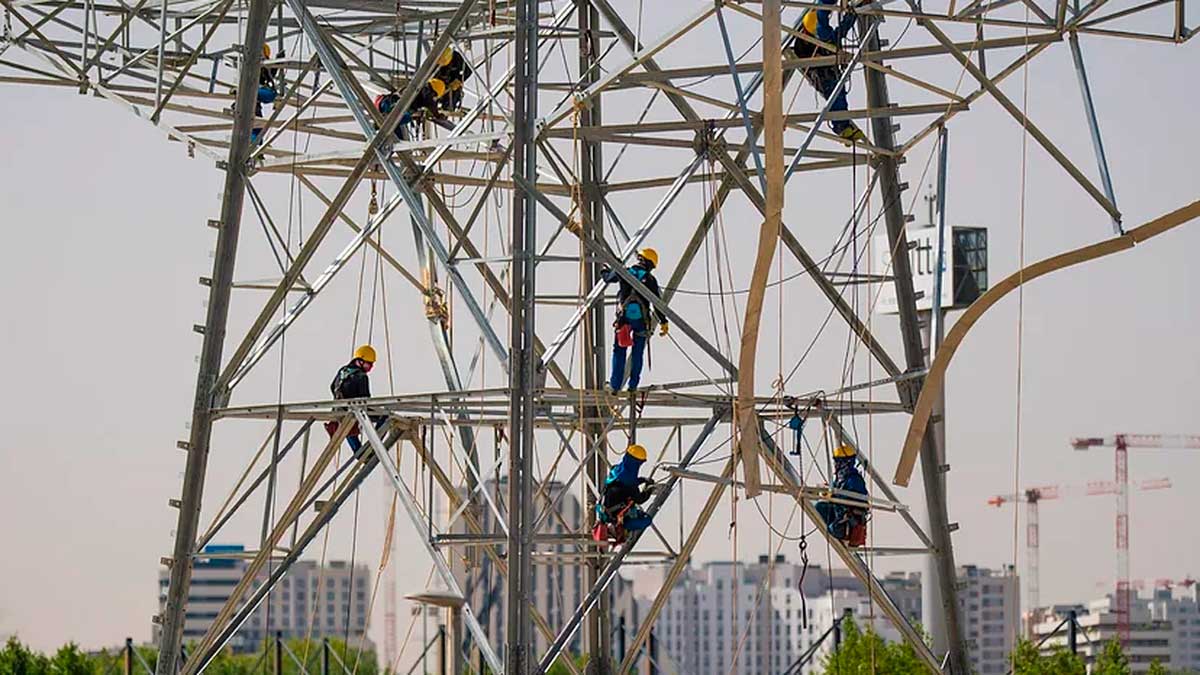 Trabajadores en torre de alta tensión en La Moraleja realizando labores de mantenimiento