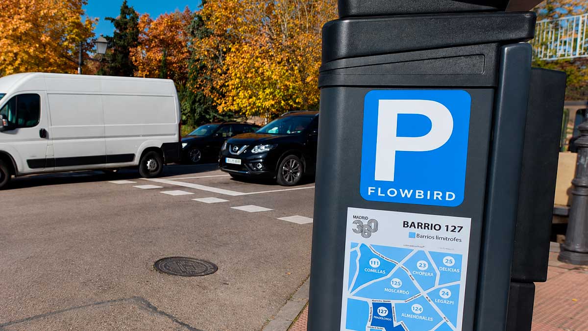 Parquímetro de la zona SER en Madrid con coches aparcados y señalización visible